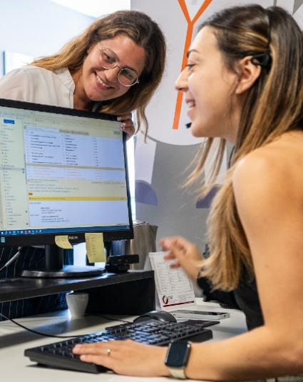 Due donne lavorano insieme al computer in un ufficio.