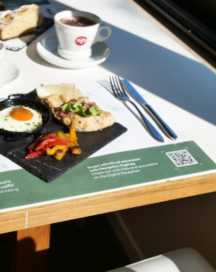 Colazione con uovo al tegamino, verdure grigliate, pane e una tazza di caffè.