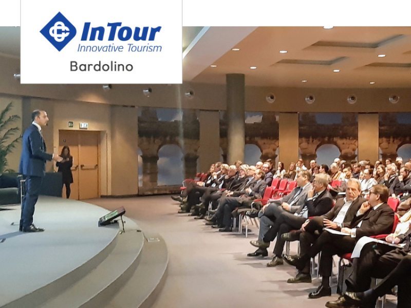 Conferenza InTour a Bardolino con numerosi partecipanti e un relatore sul palco.