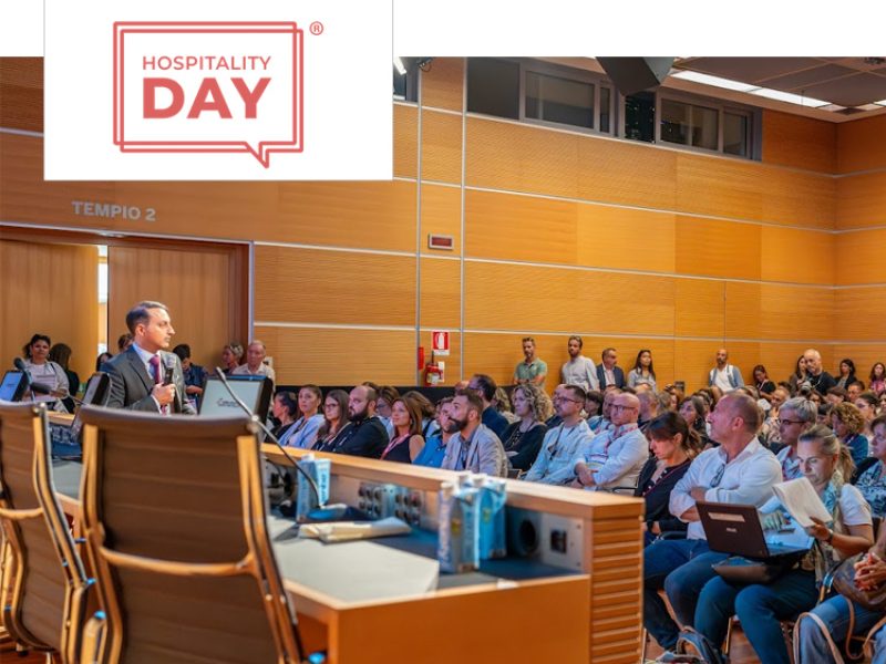 Evento Hospitality Day: conferenza con numerosi partecipanti in una sala moderna.