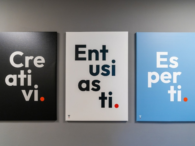 Tre poster con parole: Creativi, Entusiasti, Esperti, su sfondi nero, bianco e azzurro.